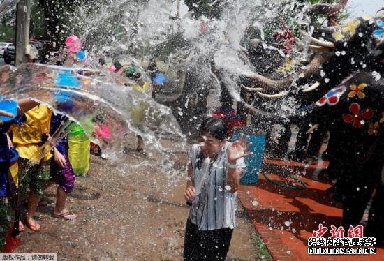 资料图：当地时间2019年4月11日，泰国大城府，当地庆祝佛教新年宋干节，狂欢者和大象互相泼水。