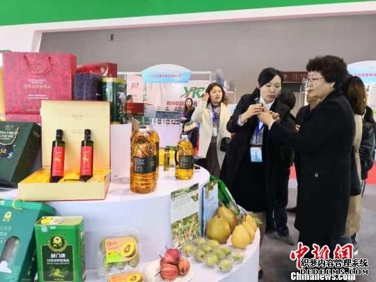 图为展商介绍广元橄榄护肤油。　刘薛梅 摄
