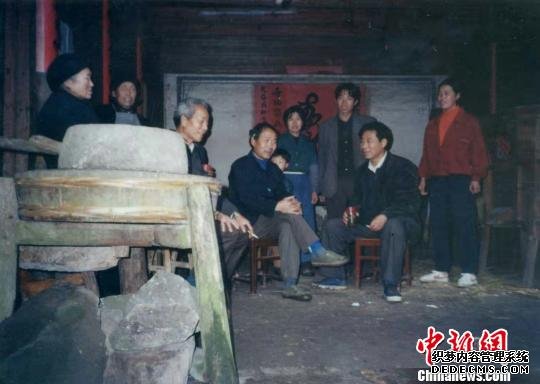 董春法和山民坐在一起做搬迁下山工作。董春法供图