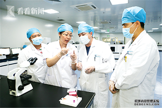 天津援疆医疗专家杨军（中）正在进行外周血涂片查看教学示范