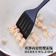 步骤图:油热后倒入虾仁，用锅铲翻炒2分钟至变色，盛出碗中备