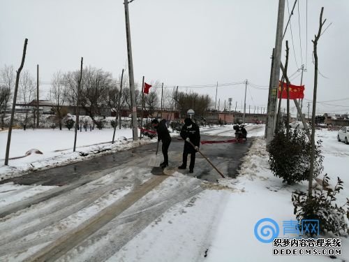 2月15日，李强（左）和村主任张世开清理进出村主路积雪