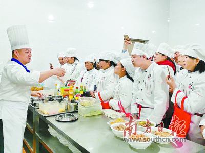 　中式烹调高级技师罗俊发（左）为学员们讲解厨房佐料的用法。