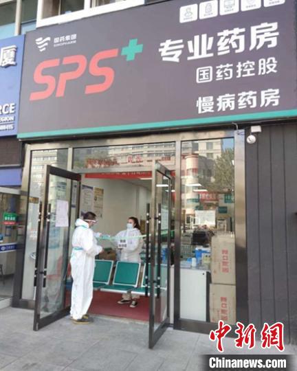 防疫人员在就近药店给居民取药。乌鲁木齐市卫健委提供